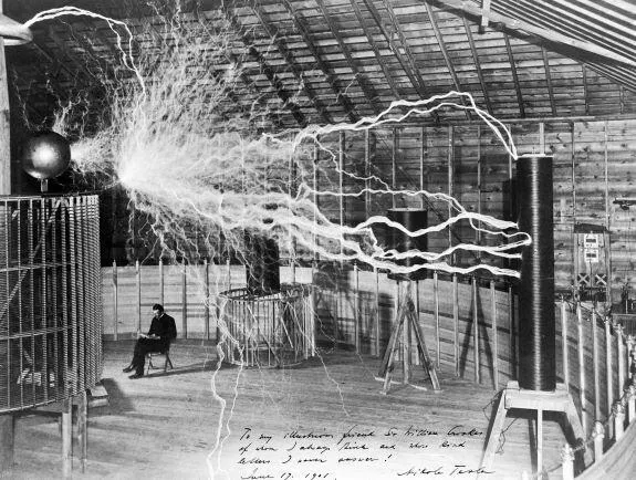 A multiple exposure picture of Tesla sitting next to his "magnifying transmitter" generating millions of volts. The 7-metre (23 ft) long arcs were not part of the normal operation, but only produced for effect by rapidly cycling the power switch