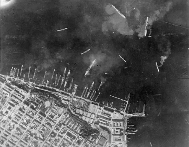 Aerial view of the inner harbour showing damaged Trento-class cruisers surrounded by floating oil