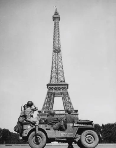 American soldiers watch the French flag flying on the Eiffel Tower, c. 25 August 1944
