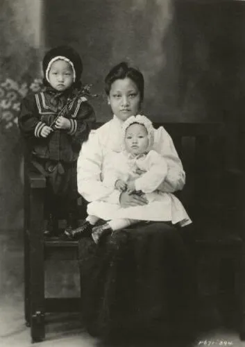 Anna May Wong seated in her mother's lap, c. 1905