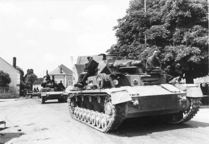 German Panzer IV tanks passing through a town in France