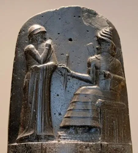 Hammurabi (standing), depicted as receiving his royal insignia from Shamash (or possibly Marduk)