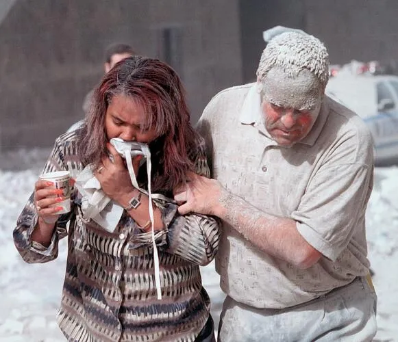 Two survivors are covered in dust after the collapse of the towers