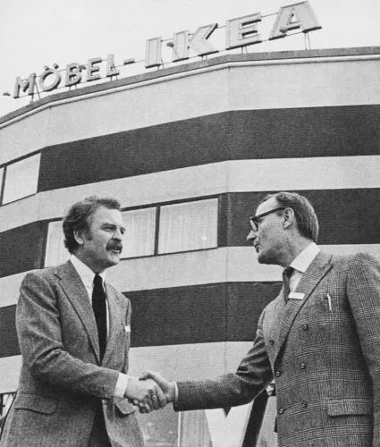Hans Ax (left), IKEA's first store manager, shakes hands with IKEA founder Ingvar Kamprad