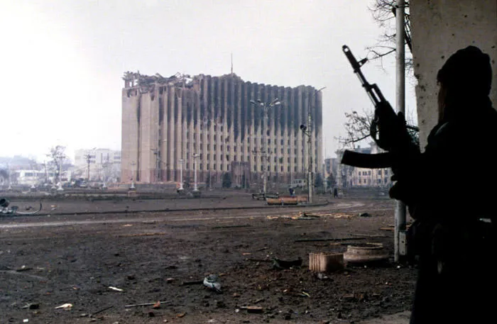 First Chechen War (A Chechen fighter stands near the government palace building during a short lull in fighting in Grozny, Chechnya) Image