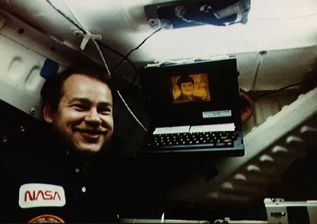 Astronaut John O. Creighton poses with onboard GRiD Compass computer - image