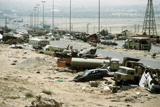 Demolished vehicles line Highway 80, also known as the "Highway of Death", the route fleeing Iraqi forces took as they retreated fom Kuwait during Operation Desert Storm Image