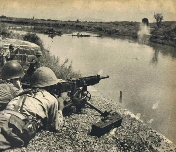 A Japanese soldier firing a Type 92 Heavy Machine Gun across the Miluo river in September 1941