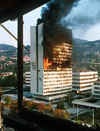 Bosnian War (The government building in the centre of Sarajevo burns after being hit by tank fire during the siege in 1992) Image